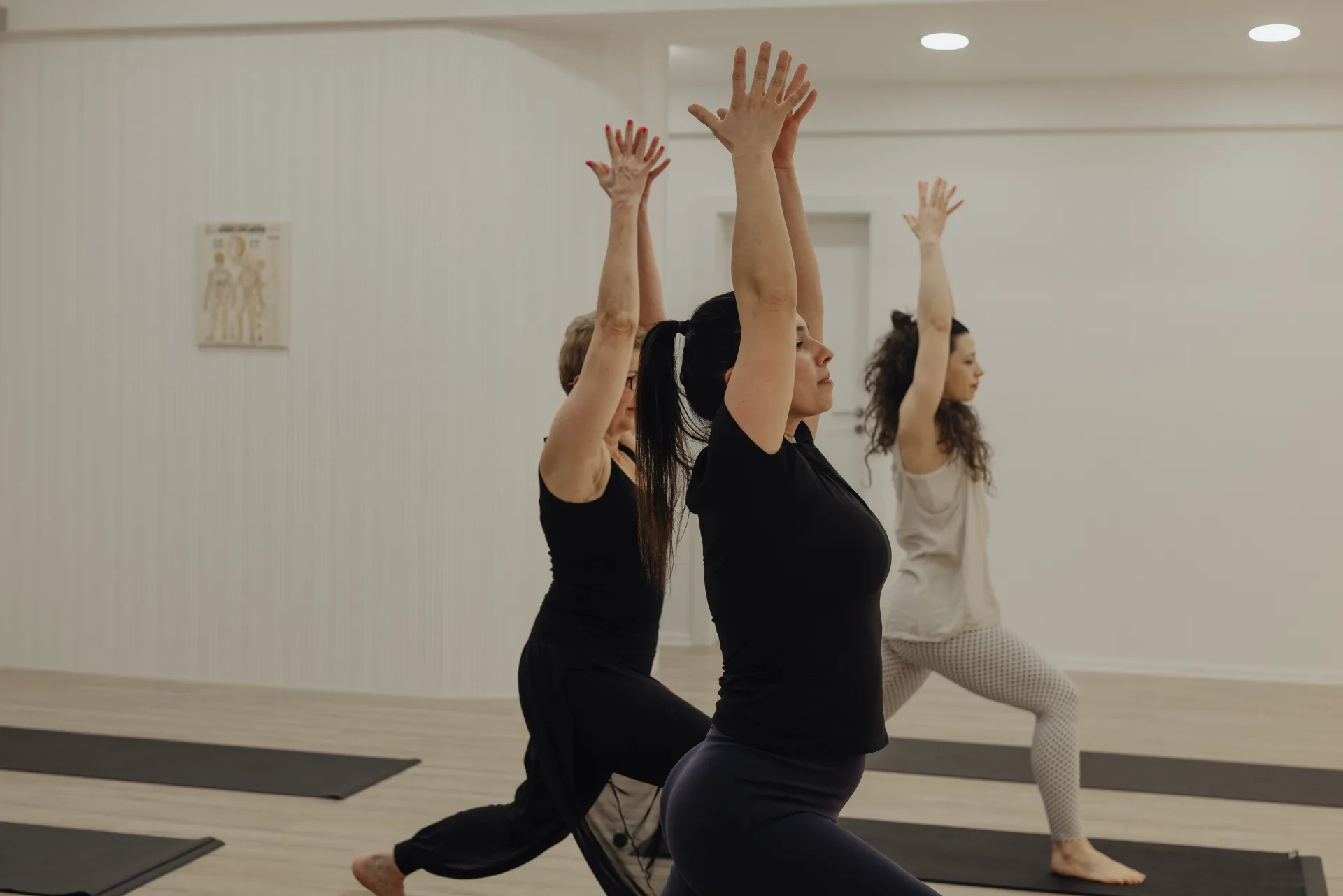 Clasă de grup la The Studio — poziție warrior cu brațele ridicate